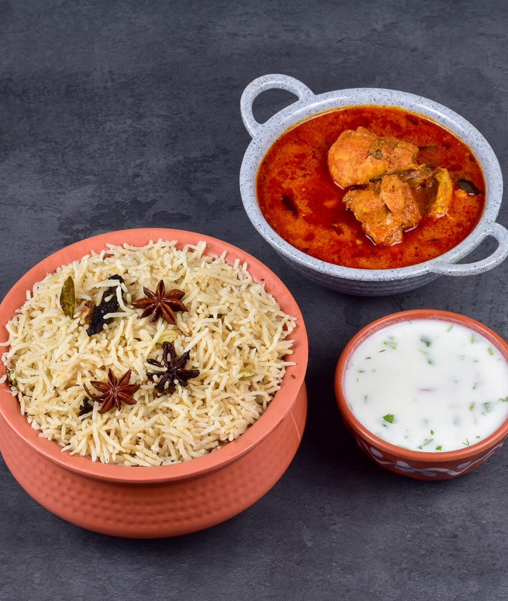 Bagara Rice served with spicy Chicken Curry in terracotta bowls